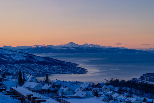 A beautiful northern city Narvik with snowy mountains over the fjord. Norway scenery of a town in arctic day. Arctic nature in Scandinavia during winter season.