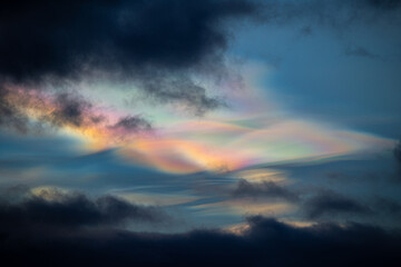 A rare polar stratospheric cloud display in the winter skies in Norway. Colorful ice crystals in the sky in sun rays. Arctic nature in Scandinavia during winter season.