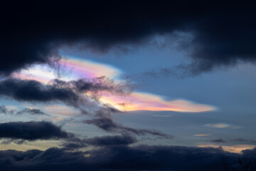 A rare polar stratospheric cloud display in the winter skies in Norway. Colorful ice crystals in the sky in sun rays. Arctic nature in Scandinavia during winter season.