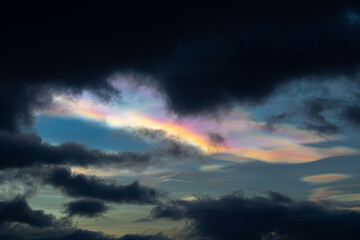 Obraz premium A rare polar stratospheric cloud display in the winter skies in Norway. Colorful ice crystals in the sky in sun rays. Arctic nature in Scandinavia during winter season.