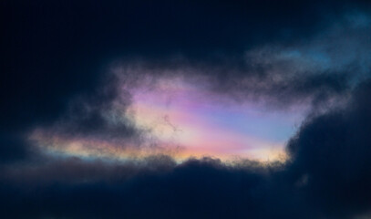 A rare polar stratospheric cloud display in the winter skies in Norway. Colorful ice crystals in the sky in sun rays. Arctic nature in Scandinavia during winter season.