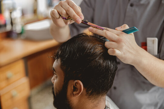 A skilled professional barber offers stylish haircut services in a modern and inviting salon environment