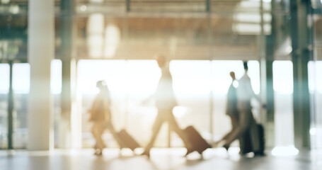 Blurred background, travel and business people in an airport with suitcase for departure on an international flight. Flare, luggage and an employee group walking in a terminal or lobby for boarding