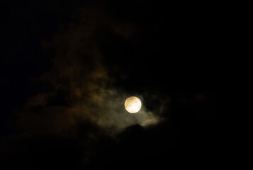 a bright blue cloud with translucent clouds against a dark sky