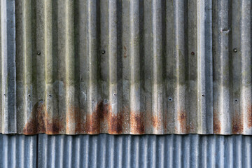 Old zinc wall has a vertical, overlapping pattern.