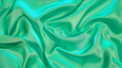 Obraz premium Luxurious green silk fabric with smooth folds for elegant textile design