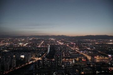 Fototapeta premium Evening Beijing city skyline with mountains in background