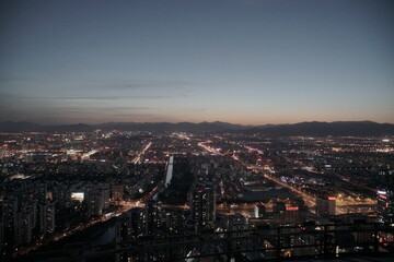 Evening Beijing city skyline with mountains in background