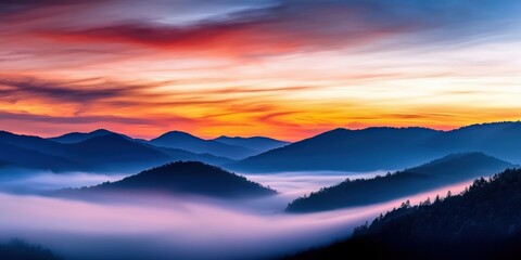 Obraz premium Pastel-colored sky at sunrise over rolling fog-covered hills, dreamy and peaceful mountain landscape