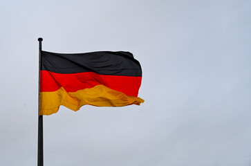 Flag of Germany waving against sky on flagpole