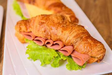 Croissant sandwich delight bakery food photography cozy setting close-up culinary art