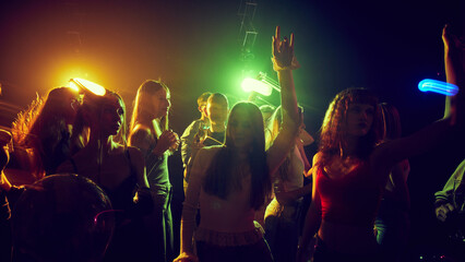 Young people, men and women gathering together, attending concert, party, cheerfully dancing and having good time. Concept of youth culture, party, fun and leisure © master1305