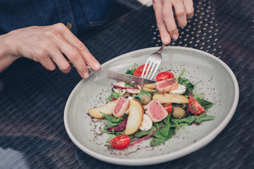 Close-up of woman having healthy fresh vegetable salad outdoors