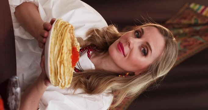 beautiful russian girl with a stack of pancakes with red caviar on russian Maslenitsa
