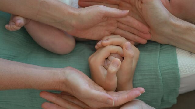 A touching family moment where father, mother, and elder son open their arms to form a flower-like pose, revealing the tiny hand of their newborn baby in the center. A symbolic gesture of love, unity
