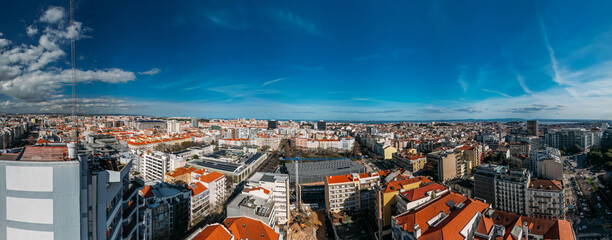 Aerial drone panoramic cityscape view showcasing the vibrant buildings and blue sky of Saldanha in Lisbon during daytime