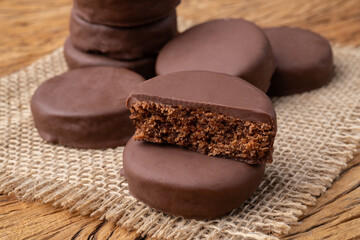 Brazilian Pao de Mel or chocolate covered honey cookies over a wooden table