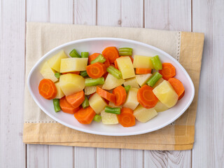 Cooked vegetables in a plate over wooden table