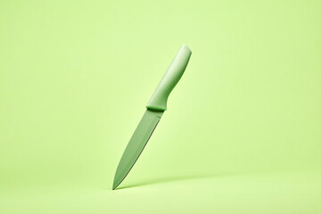 Bright green cooking chef's stylish modern design kitchen knife on the bright solid fond plain bright green background