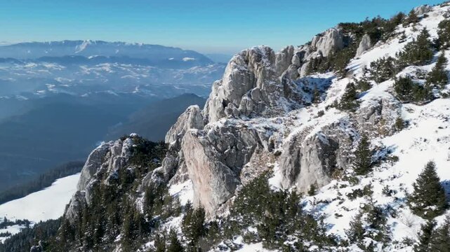 Drone view of the snowy peaks of the Bucegi Mountains of Romania on a sunny day
