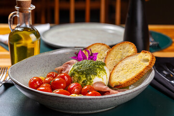 Salad with cherry tomatoes, bread, white cheese and ham