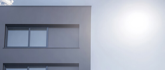 Modern architecture with large windows under a bright sky near sunset