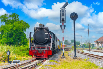 Vintage black steam locomotive train stands at the traffic light in front of the departure station railway