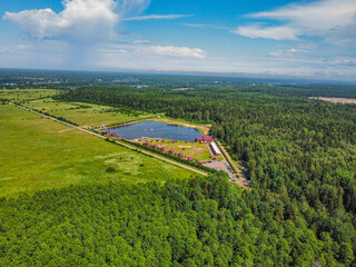 An artificial lake and houses on the shore with a forest in the background