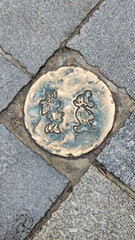 Bronze Sidewalk Art with Playful Cartoon Characters