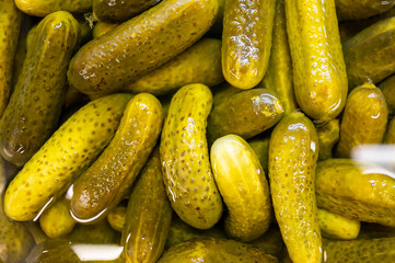 Fresh, crunchy pickles submerged in brine, showcasing their vibrant green color and smooth...