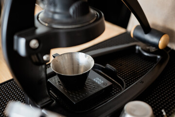 manual coffee press with metal cup on digital scale, ready for brewing. setup is on textured mat, highlighting precise and artisanal coffee making process