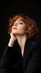 A woman with red hair is sitting on the floor with her hands on her knees