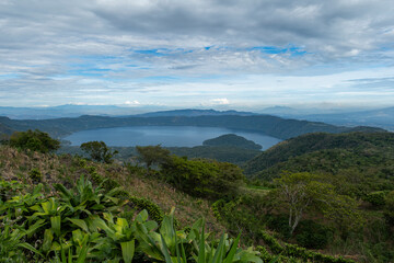 Wide angle panoramic aerial view of Lake Coatepeque with Teopan Island - inactive volcano crater lagoon in western mountain region of El Salvador near Santa Ana city.	
