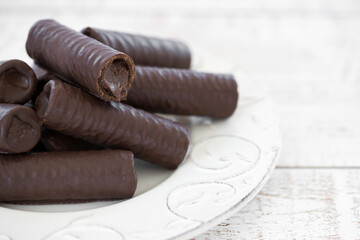 Sweet chocolate covered rolls - table arrangement, isolated on white background. Selective focus....