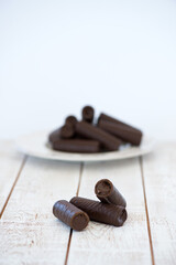 Sweet chocolate covered rolls - table arrangement, isolated on white background. Selective focus. Copy space.