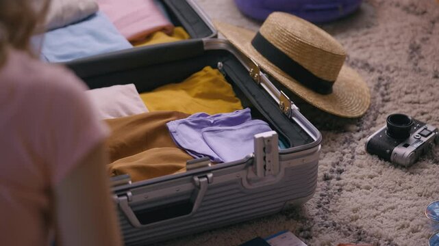 Woman carefully packs her suitcase for vacation, getting ready for an adventure