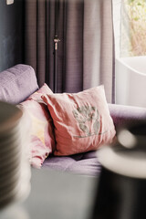 Colorful pillows on purple sofa, interior