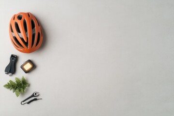 creative flat lay of eco-friendly transport items like helmet led lights and bike tools arranged on neutral surface