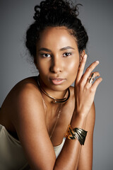 Obraz premium Elegant African American woman showcasing exquisite jewellery in a chic urban setting