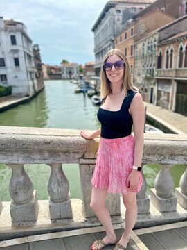 Jeune femme en top noir d&eacute;collet&eacute; et mini-jupe rose &agrave; Venise