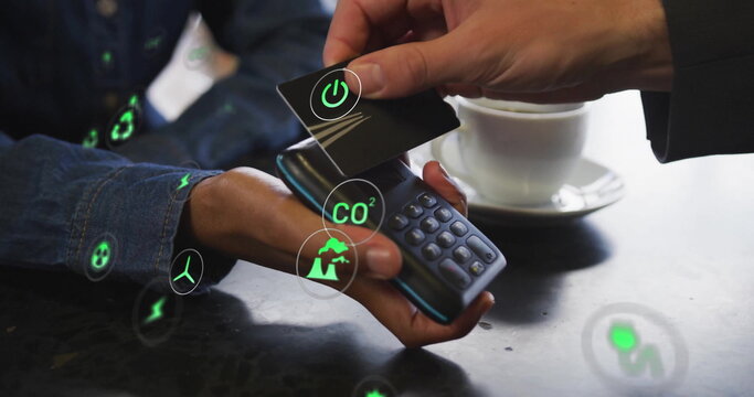 Image of network of eco icons over caucasian man paying with card