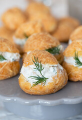 Close up of traditional French savory choux dough cheese puff stuffed with fresh cheese mixed with smoked salmon and dill leaves. Pastry well know as specialty of Burgundy dish.