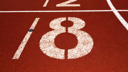 Close-up of a running track&rsquo;s starting lines with lane numbers clearly visible