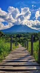 Fototapeta premium Scenic wooden pathway leading to majestic volcano under blue sky and clouds