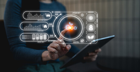 A person interacts with a digital interface on a tablet, displaying various data visuals and icons, indicating technology and data analysis.