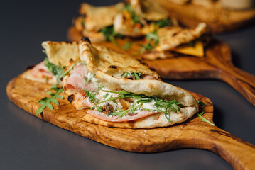 Close up of Pizza-Sandwich with Mortadella and Roasted Eggplant – composition with Pizza Sandwiches Served on Wooden Platters in a Rustic Setting