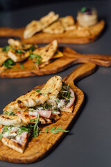 Pizza-Sandwich with Mortadella and Roasted Eggplant – Vertical composition with Sandwiches Served on Wooden Platters in a Rustic Setting