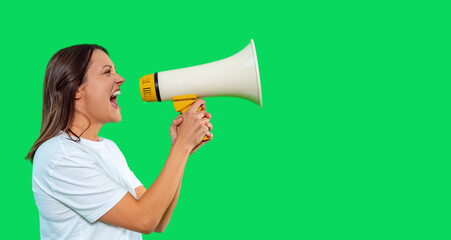 Woman passionately delivering message using megaphone in front of bright green background during a campaign or rally