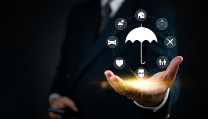 Businessman holding a glowing umbrella icon with insurance symbols representing health, home, car,...