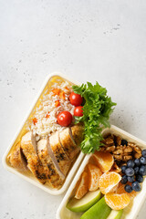 Lunch box with chicken, rice, vegetables, tomatoes, salad, fruits